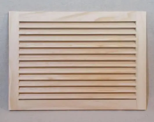 A wooden louvered vent on the wall.