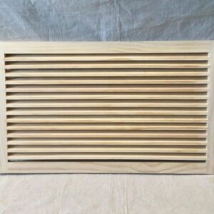 A wooden air vent on top of a white sheet.