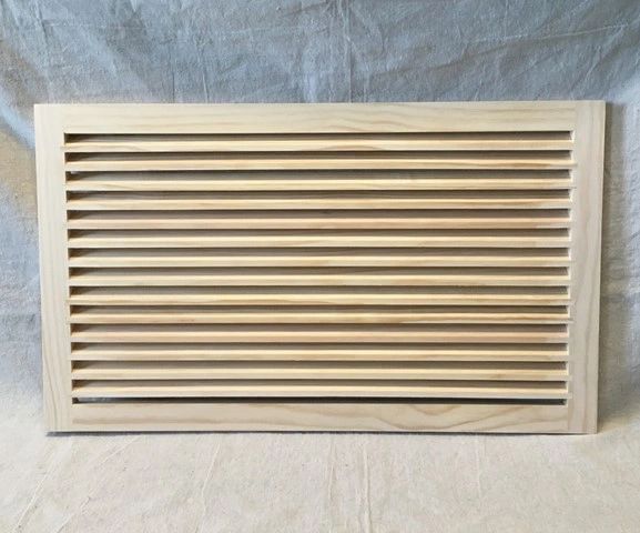 A wooden air vent on top of a white sheet.