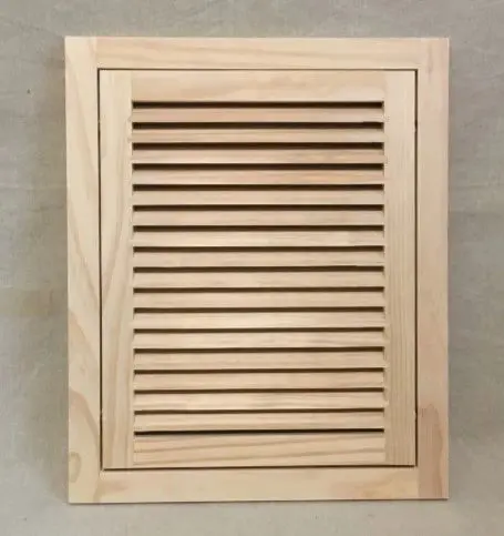 A wooden cabinet door with slats on the top.