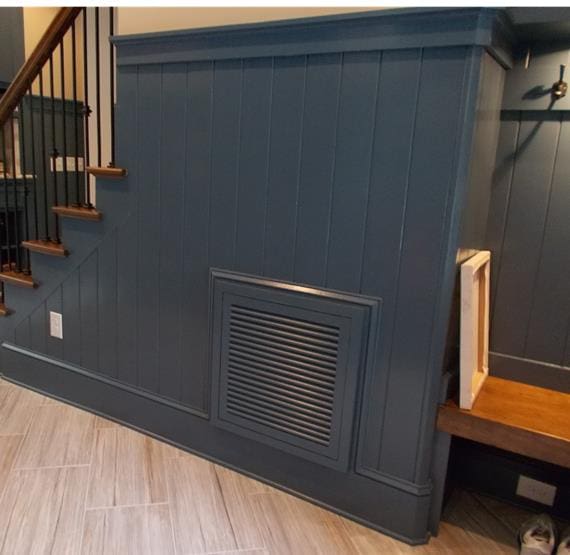 A blue wall with an air vent and stairs