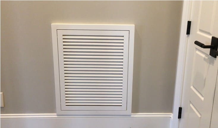 A white air vent in the corner of a room.